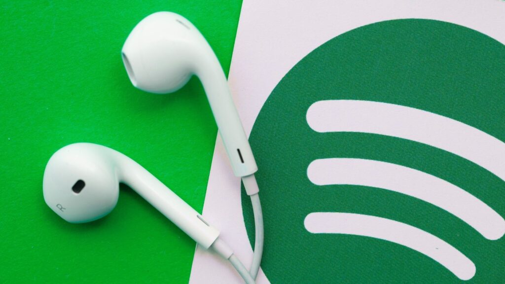 spotify marketing logo with apple earbuds on display on with a green background